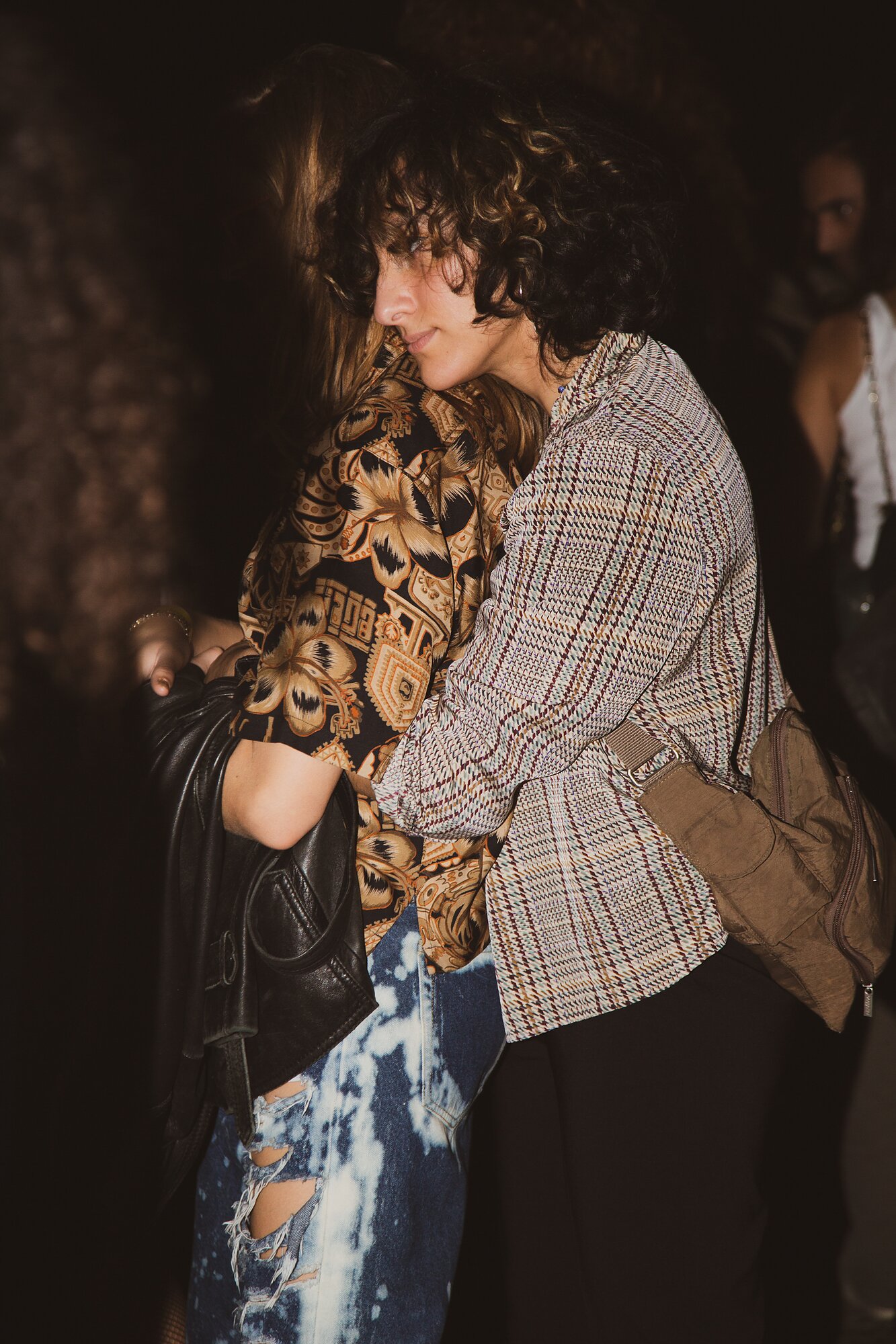 A person embraces another from behind while looking ahead.