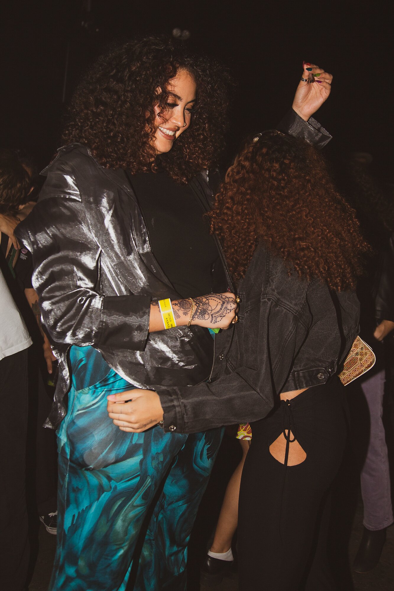 Two people dancing together with similar curly hair.