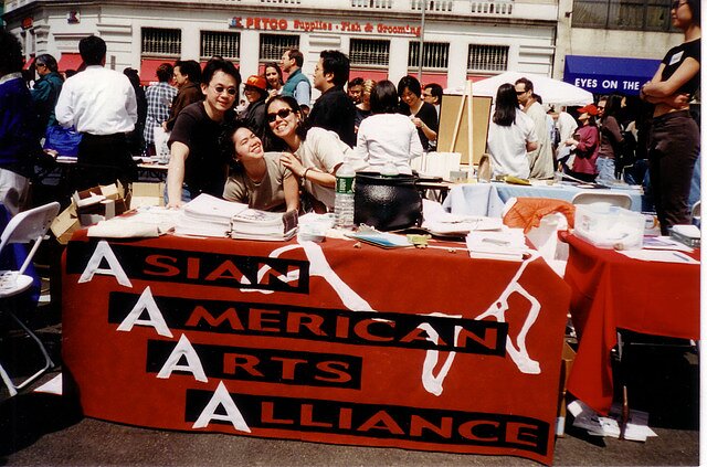 Photograph of some of the Asian American Arts Alliance's members manning a booth in NYC's Union Square in 1989.