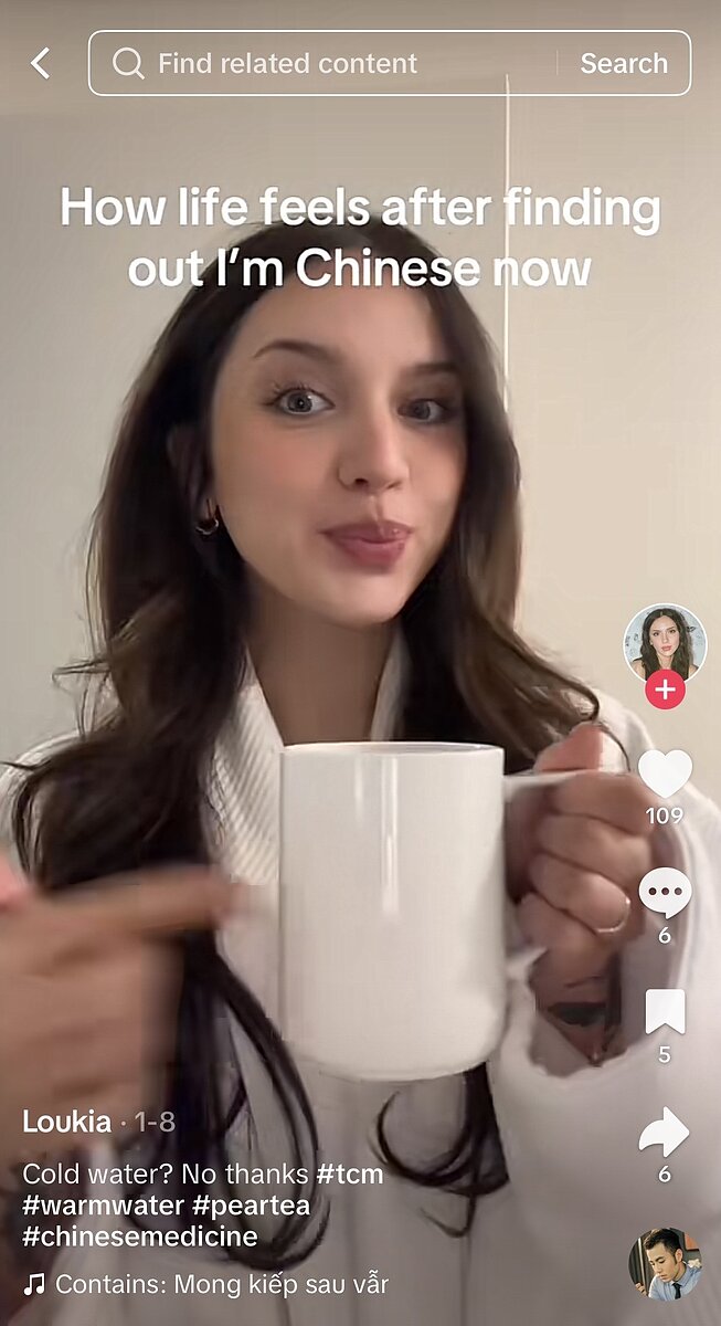 A TikTok screenshot of a non-Chinese woman holding a mug with the words "How life feels after finding out I'm Chinese now."