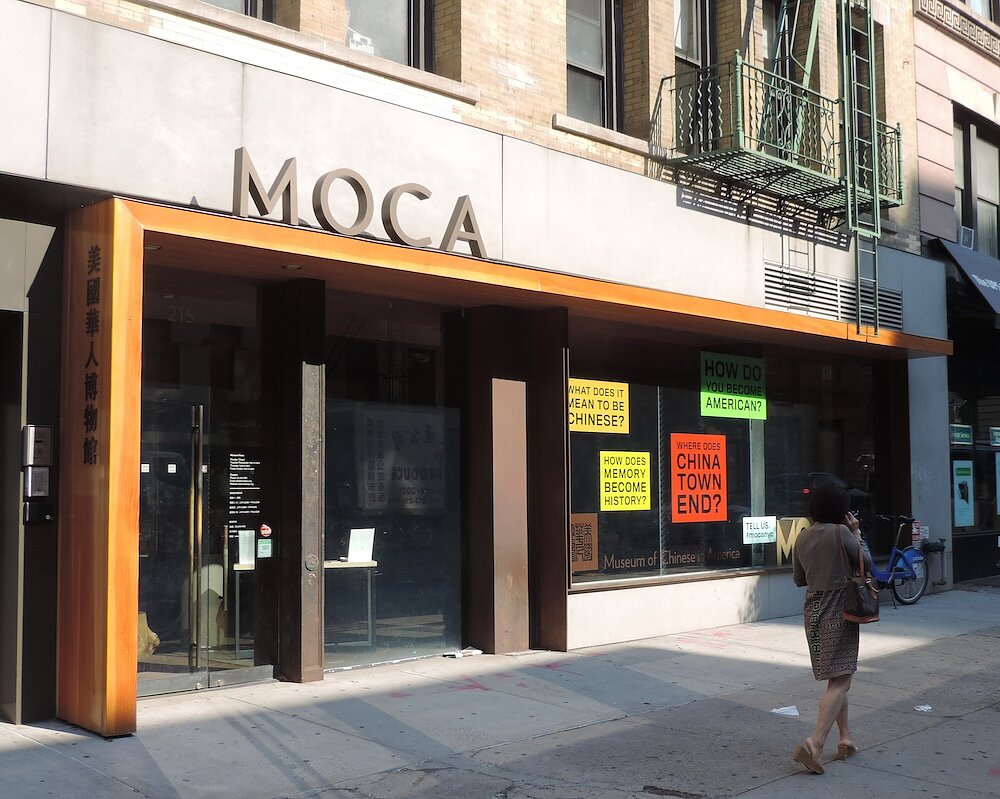 A concrete, wood, and steel museum facade with the word "MOCA" above its entrance. 