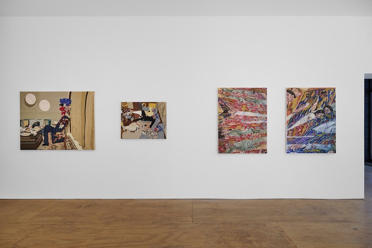 A gallery featuring four paintings hung on a white wall.