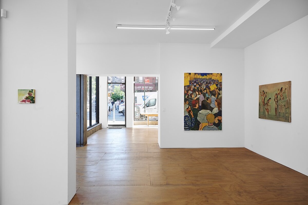 A sunlit gallery space featuring paintings hung on white walls.