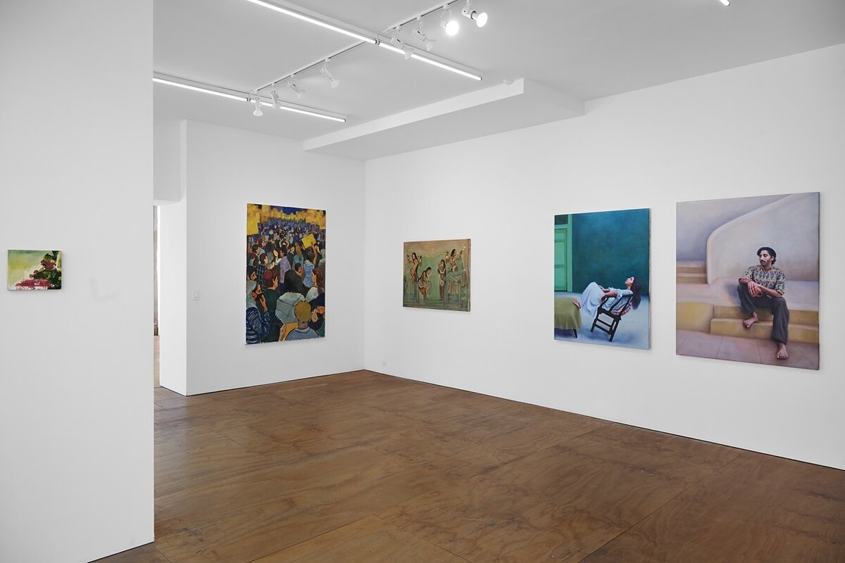 A gallery featuring a series of colorful paintings hung on white walls.