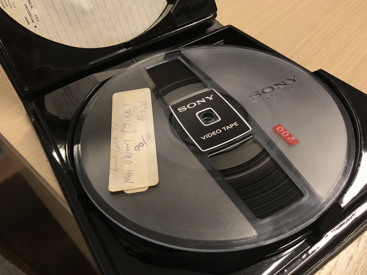 A 1/2 inch open-reel videotape with a label on it. 