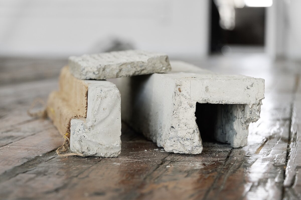 A close up shot of concrete forms arranged on a wooden floor. 